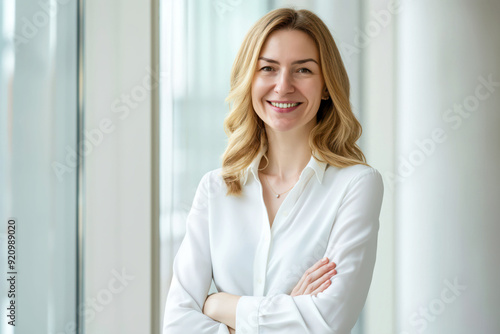 Free Download Confident Female Professional with Arms Crossed Smiling in Bright Office Environment - GFXLoad