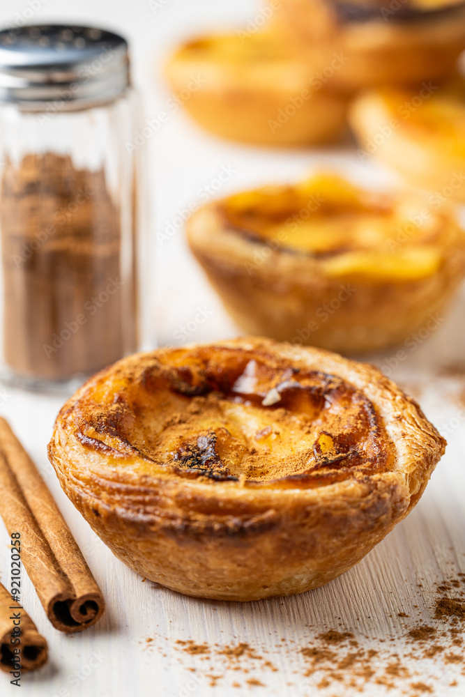 Traditional Portuguese Custard Tart (Pastel de Nata) with Cinnamon Powder and Sticks Traditional Portuguese Custard Tart (Pastel de Nata) with Cinnamon Powder and Sticks