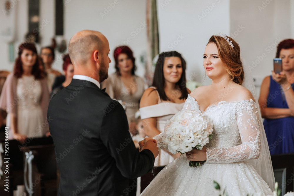 Naklejka premium A bride and groom are getting married in a church. The bride is wearing a white dress and the groom is wearing a suit. The bride is holding a bouquet of flowers and the groom is holding her hand