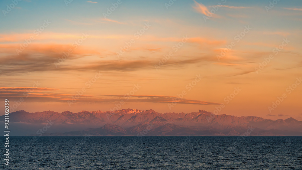 Sunset over the snow capped rocky peaks of the mountains of the Mediterranean island of Corsica Sunset over the snow capped rocky peaks of the mountains of the Mediterranean island of Corsica