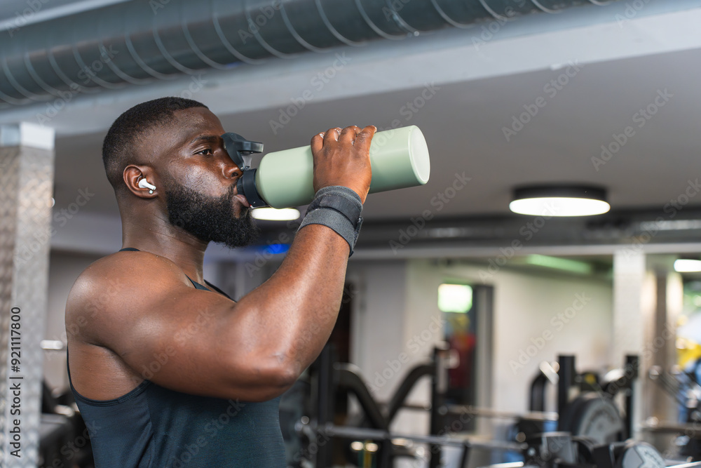 Black man drinking water during workout at the gym Black man drinking water during workout at the gym