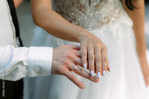 The wedding rings on the hands of the newlyweds.