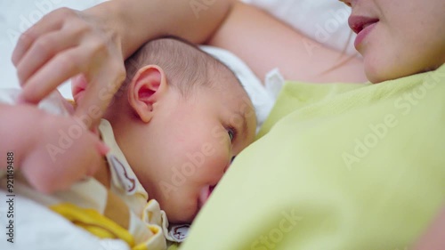 A baby is drinking milk from his mother's breast.