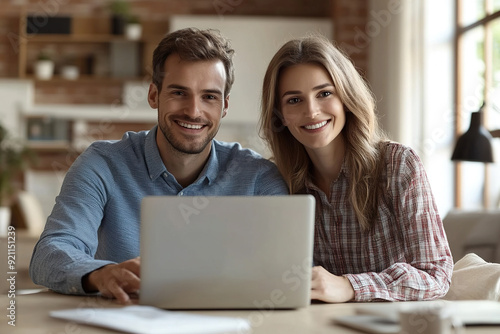 Couple Smiling as Businessman Shows House Image on Laptop