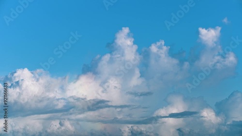 A serene blue sky with fluffy white clouds slowly drifting upwards. Captured in the afternoon, this tranquil scene showcases the beauty of nature. Toucheng, Yilan, Taiwan. photo