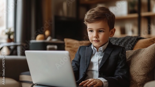 Young Entrepreneur: A young boy in a suit, focused intently on his laptop, embodies the spirit of modern childhood ambition and digital literacy.  photo