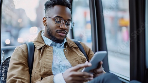 Urban Commute Chronicles: A young Black man engrossed in his phone, navigating the digital world amidst the bustle of city life during his daily commute.