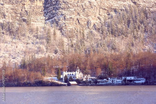 Snow-covered estate by Hallstatter See in Hallstatt, Austria, nestled against a wintery mountainside photo