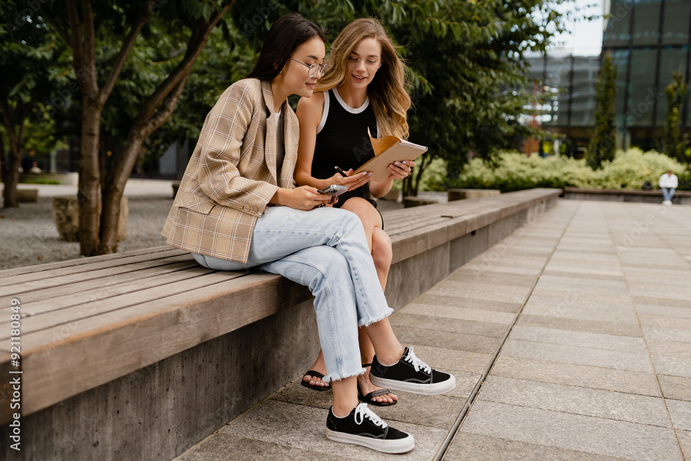 young pretty women sitting outside in street doing business young pretty women sitting outside in street doing business