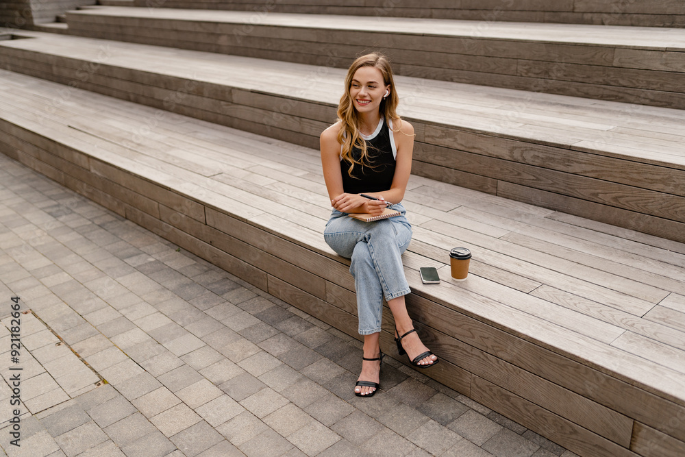 Obraz premium young pretty woman sitting in student campus co-working outside