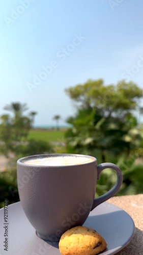 Wallpaper Mural Peaceful morning scene with cup of coffee and biscuit on saucer, set against backdrop of sunlit trees perfect for starting day with calm and tranquility. Morning Coffee Break Bright cheerful outdoor Torontodigital.ca