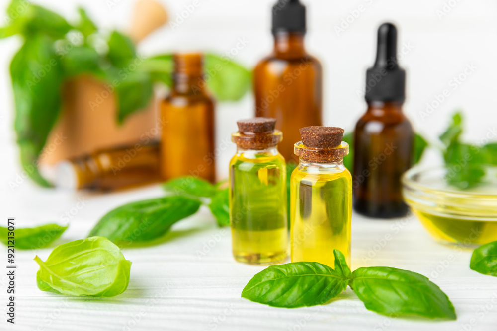 Obraz na plátně Basil essential oil on a textured wooden background