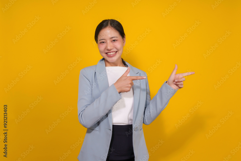 Smiling businesswoman pointing two opposite directions with index fingers on yellow background Smiling businesswoman pointing two opposite directions with index fingers on yellow background
