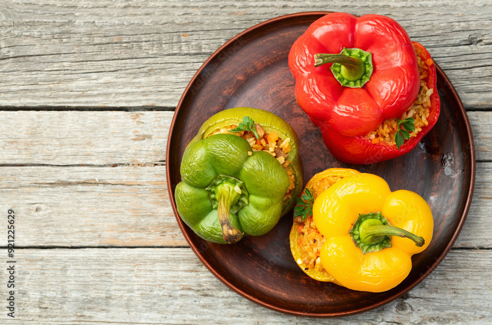 Baked stuffed pepper ( paprika ) with rice , carrot and meat . Top view on rustic background Baked stuffed pepper ( paprika ) with rice , carrot and meat . Top view on rustic background