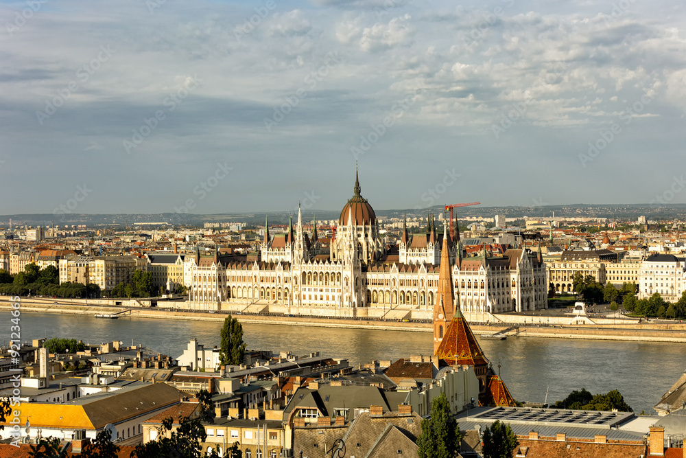 Fototapeta premium Budapest Hungary. View of the capital in Europe. Cruises ship passes on the Danube River. The imposing Parliament in the background. The bridges with cars, trams and bicycles. Concept photo