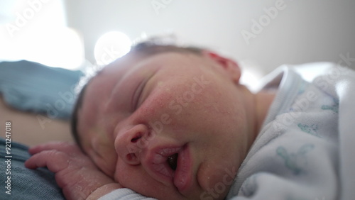 Close-up of newborn baby sleeping peacefully with eyes closed, detailed shot of serene and restful expression, cozy indoor environment, capturing tranquility and innocence of infancy photo