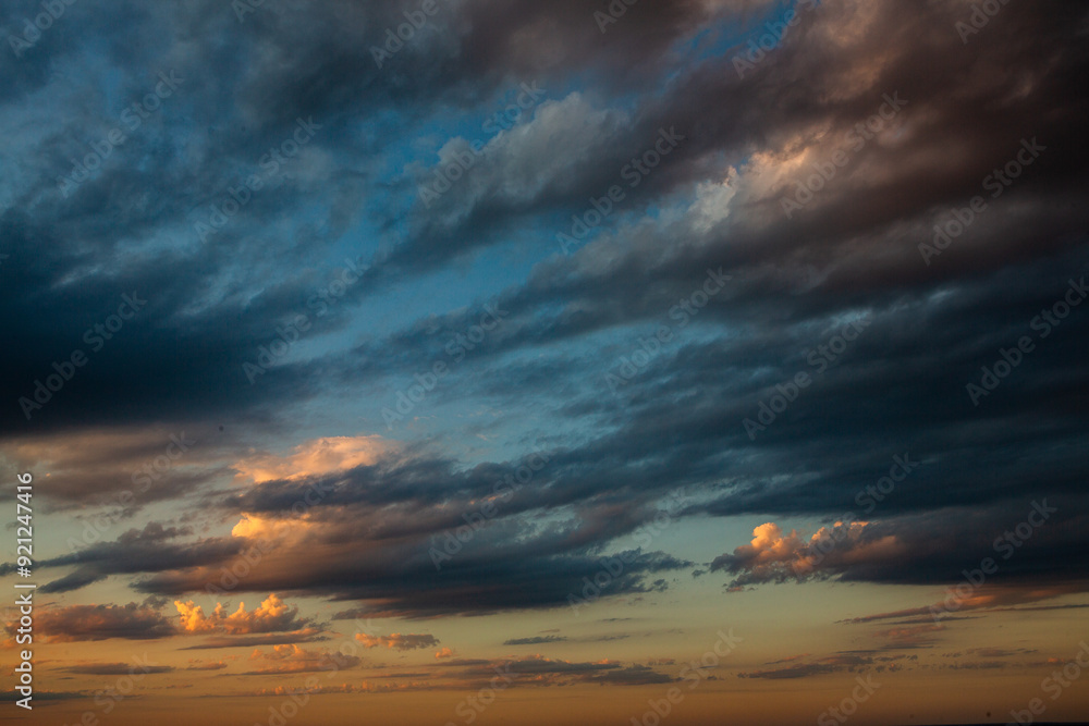Fototapeta premium Cloudscape, Colored Clouds at Sunset near the Ocean in a Cloudy Day