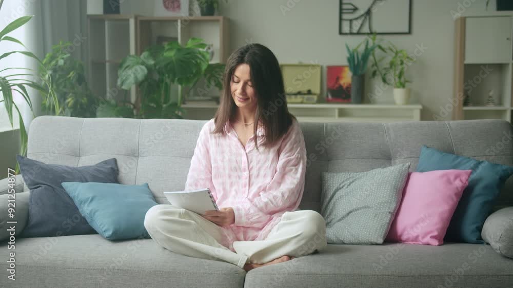 Cozy living room scene of woman enjoying digital book on tablet
