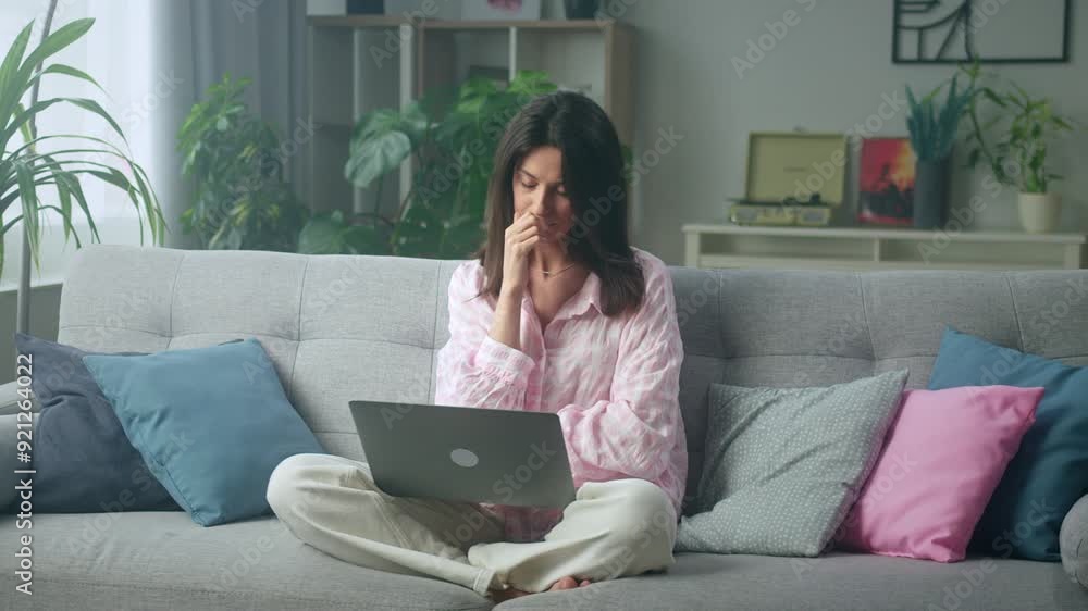 Remote worker on laptop in cozy living room Remote worker on laptop in cozy living room
