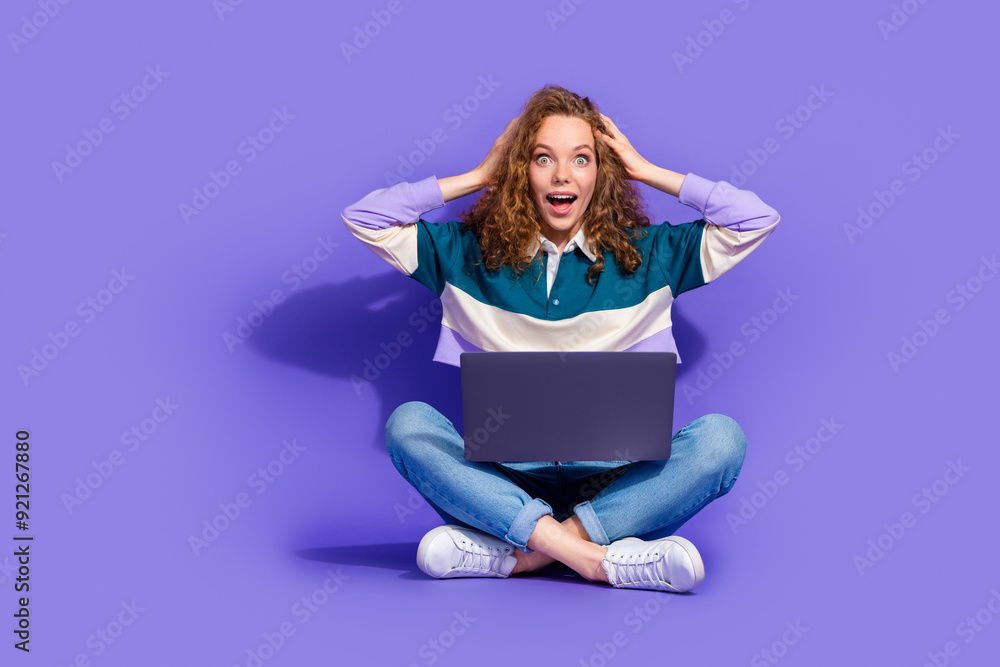 Full body portrait of pretty lovely young girl sit floor use laptop isolated on purple color background Full body portrait of pretty lovely young girl sit floor use laptop isolated on purple color background