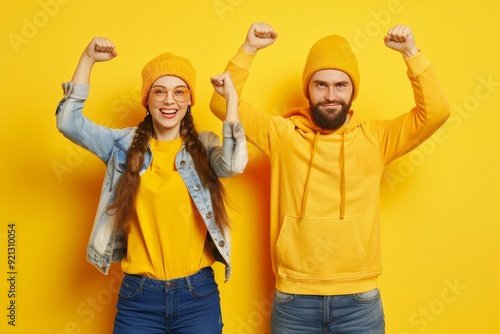 Full body photo of pair lady and guy fans supporting favorite football team raising fists wear casual outfit isolated yellow color background