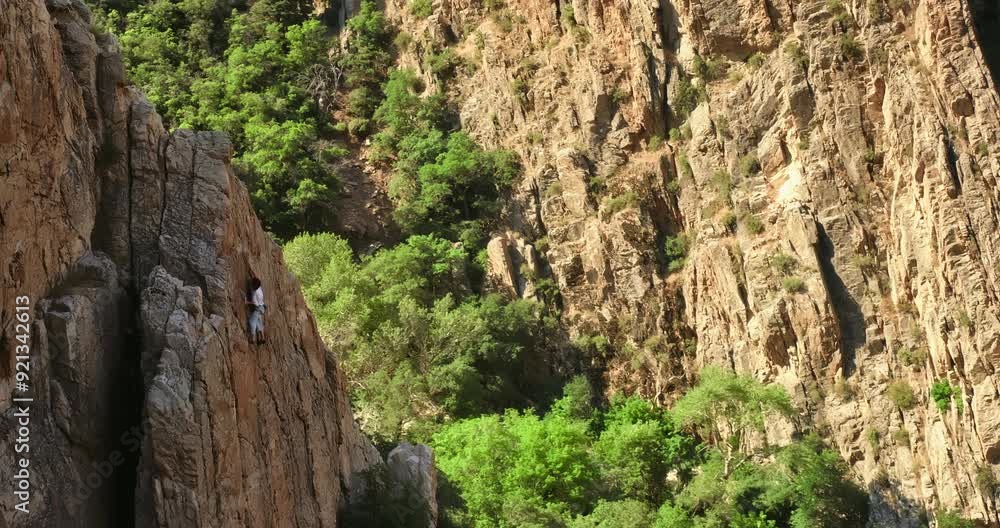 Majestic shot flying around young rock climber on mountain - sunrise glow Majestic shot flying around young rock climber on mountain - sunrise glow