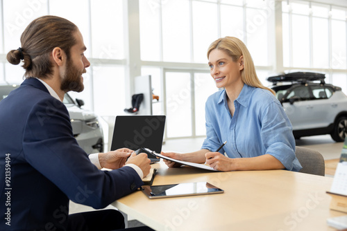 Wallpaper Mural Woman buying new automobile completes purchase with male seller in car showroom Torontodigital.ca