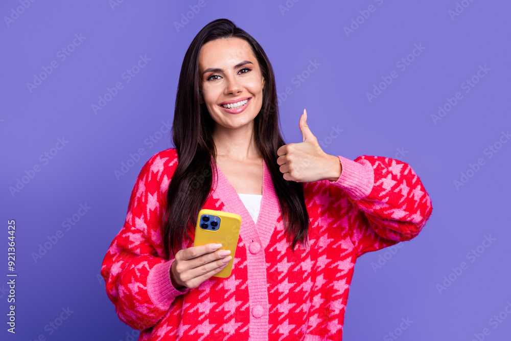 Photo of cheerful pretty lady dressed pink cardigan showing thumb up reading modern device isolated violet color background Photo of cheerful pretty lady dressed pink cardigan showing thumb up reading modern device isolated violet color background