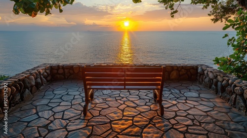 A bench is sitting on a stone wall overlooking the ocean