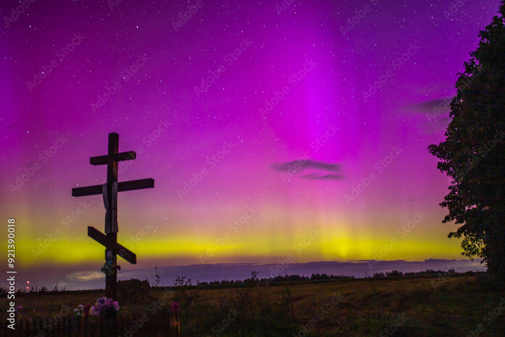 night starry sky outside the city with purple reflections of the northern lights