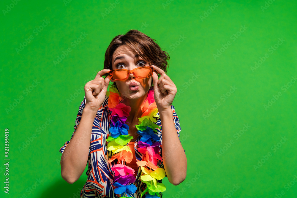 Photo of astonished woman dressed print blouse colorful necklace touch sunglass staring pouted lips isolated on green color background Photo of astonished woman dressed print blouse colorful necklace touch sunglass staring pouted lips isolated on green color background