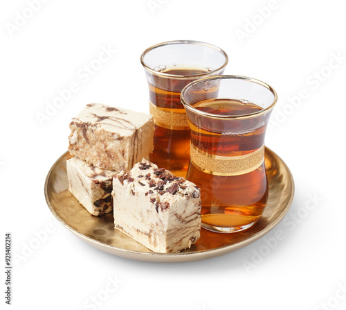 Glasses of Turkish tea and pieces of tasty marble halva on white background photo