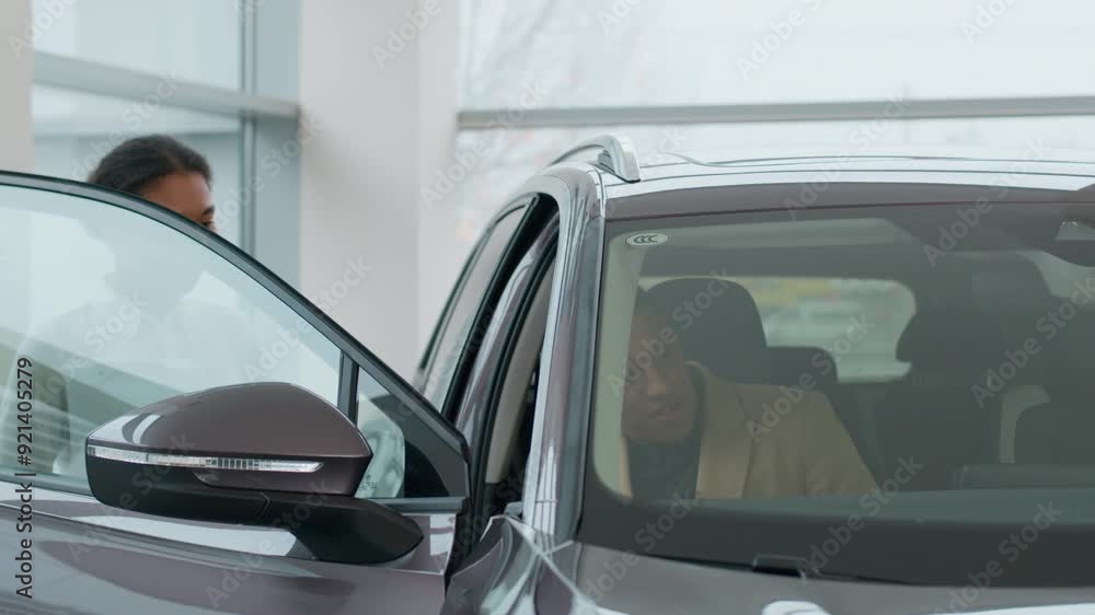 African American man buyer guy male choose buy new luxury car in salon female girl saleswoman dealer woman help client choosing automobile rent vehicle test drive sit in auto dealership credit bank African American man buyer guy male choose buy new luxury car in salon female girl saleswoman dealer woman help client choosing automobile rent vehicle test drive sit in auto dealership credit bank