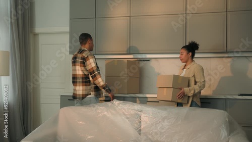 Frustrated sad couple ethnic woman man African American family upset worried home owners tenants moving out house with cardboard boxes bankruptcy leave apartment eviction divorce debt credit mortgage