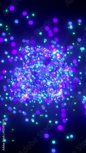 Colorful abstract particles swirling in a vibrant vertical video screen display of light and movement
