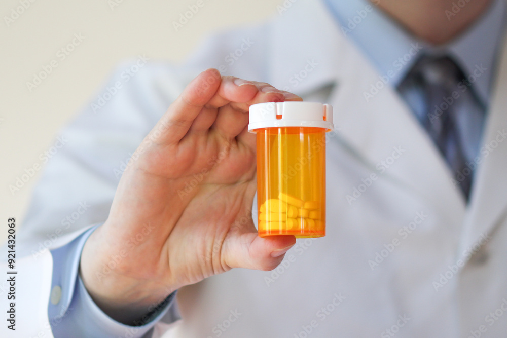 Healthcare professional holding a bottle of prescription pills Healthcare professional holding a bottle of prescription pills