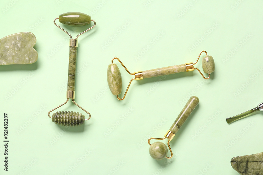 Different facial massage tools on green background Different facial massage tools on green background