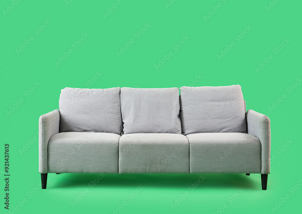 Naklejka premium Grey sofa on green background