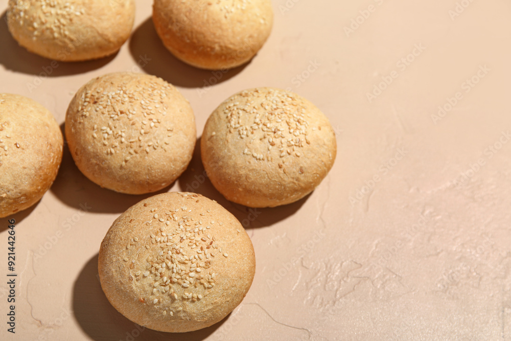 Fresh buns with sesame seeds on beige background Fresh buns with sesame seeds on beige background