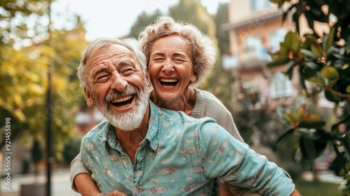 A joyful elderly couple laughing outdoors, showcasing happiness and companionship.