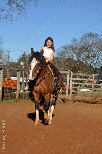 menina vaqueira cavalgando com cavalo marrom  photo