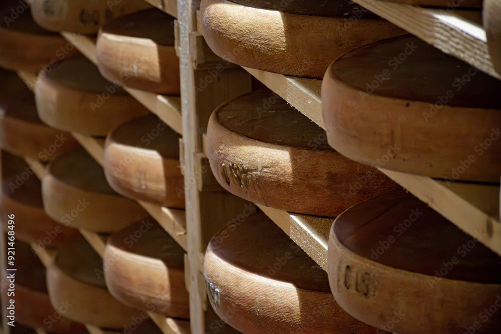 Aging rooms with shelves in cheese caves, central location for aging of wheels, rounds of Comte cheese from four months to several years made from raw cow milk, Jura, France Aging rooms with shelves in cheese caves, central location for aging of wheels, rounds of Comte cheese from four months to several years made from raw cow milk, Jura, France