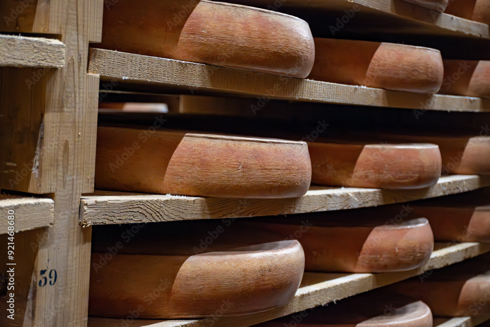 Aging rooms with shelves in cheese caves, central location for aging of wheels, rounds of Comte cheese from four months to several years made from unpasteurised cow milk, Jura, France Aging rooms with shelves in cheese caves, central location for aging of wheels, rounds of Comte cheese from four months to several years made from unpasteurised cow milk, Jura, France