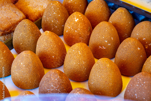 Sicilian street food arancini, deep fried rice croquettes with different fillings on market photo