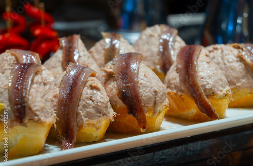 Typical snacks of Basque Country, pinchos or pinxtos skewers with small pieces of bread, fish, sea food, sweet green pepper served in bar in San-Sebastian or Bilbao, Spain photo