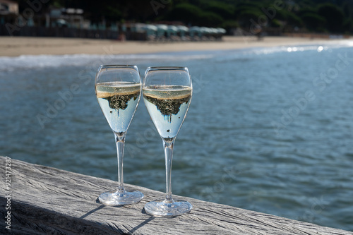 Summer time in Provence, two glasses of cold champagne cremant sparkling wine on famous Pampelonne sandy beach near Saint-Tropez in sunny day, Var department, France, beach club party photo