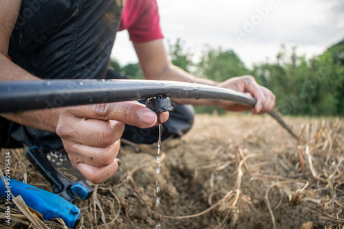 Man with Drip Irrigation Hose – Efficient Watering for Crops