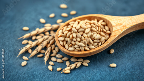 Wooden spoon with barley seeds on blue background photo