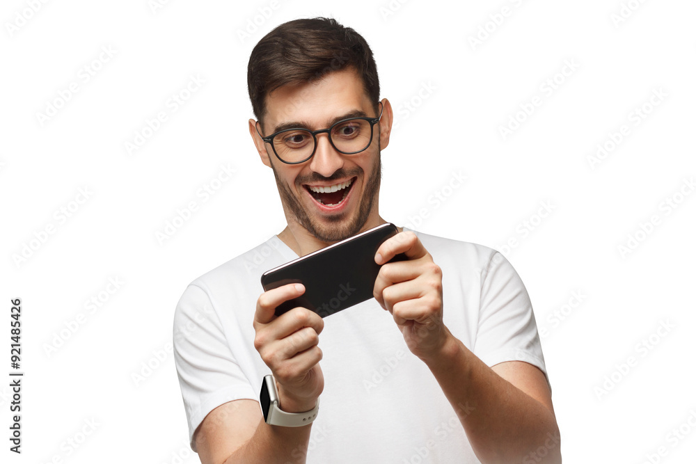 Young man holding smartphone with both hands, moving it while playing online video game in app Young man holding smartphone with both hands, moving it while playing online video game in app