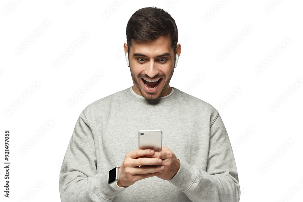 Young shocked excited man looking at his phone with surprise expression Young shocked excited man looking at his phone with surprise expression